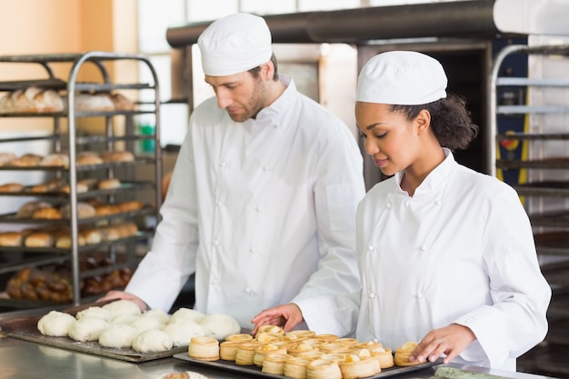 Bakers looking at trays of dough and pastry