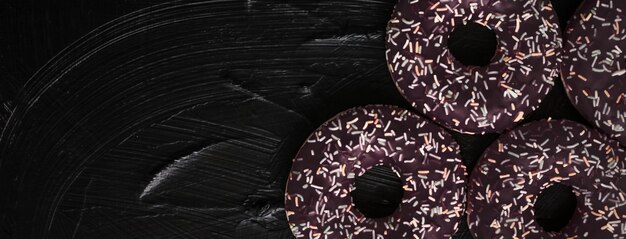 Bakery branding and cafe concept  frosted sprinkled donuts sweet pastry dessert on rustic wooden bac...