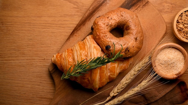 Bakery bread background with bagel croissant on a wooden plate Top view