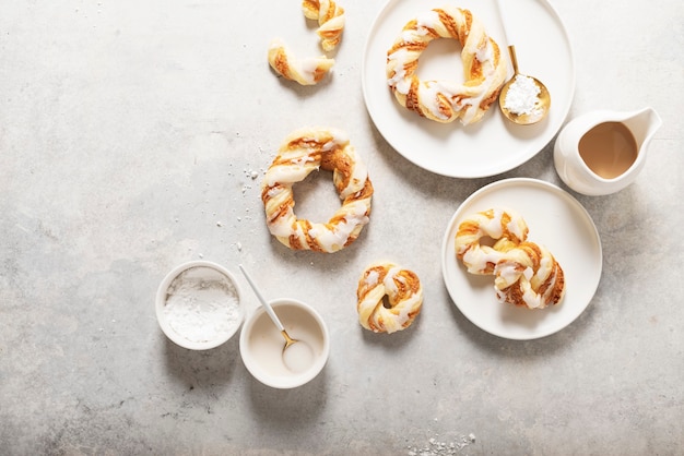 Bakery concept, sweet round desserts with glazed sugar on the light surface. Top down view.