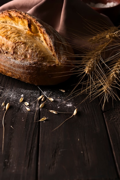 Bakery - gold rustic crusty loaves of bread and buns on black background.