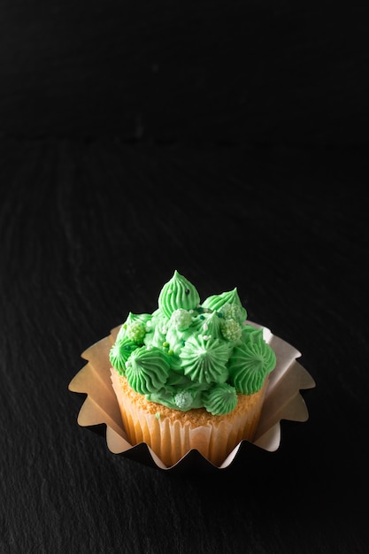 Bakery  Homemade Sponge vanilla cupcake green tone buttercream on black  