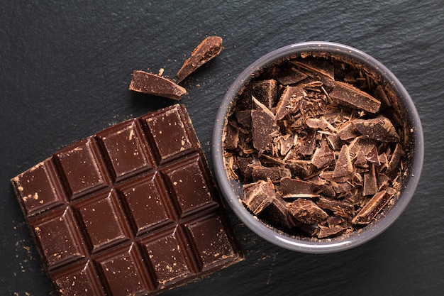 Bakery preparation Flat lay chopped milk chocolate on black background with copy space