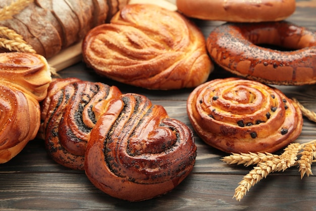 Photo bakery various kinds of breadstuff bread rolls bagel sweet bun on brown background