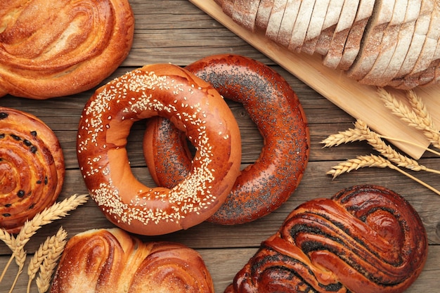 Photo bakery various kinds of breadstuff bread rolls bagel sweet bun on grey background