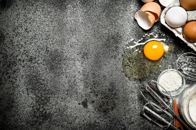 Baking background Fresh eggs from the scattered flour on rustic background