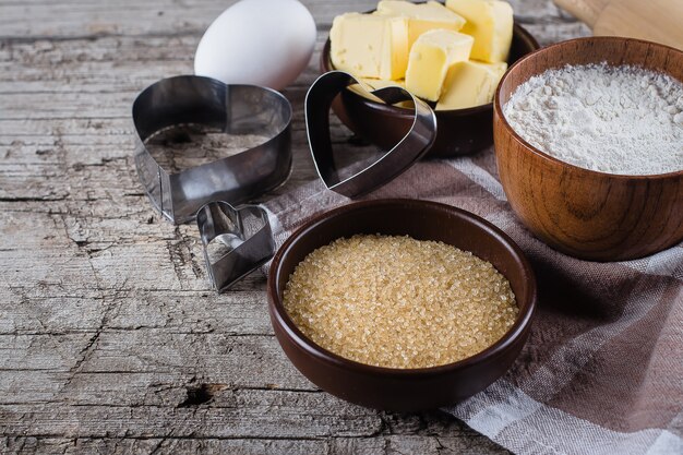 Baking background with flour, sugar, butter, rolling pin, eggs, and heart shape