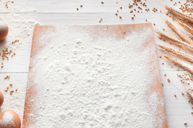 Foto classe di cottura o concetto di ricetta, farina di frumento cosparsa su tavola di legno sul tavolo. cottura di pasta o pasticceria.