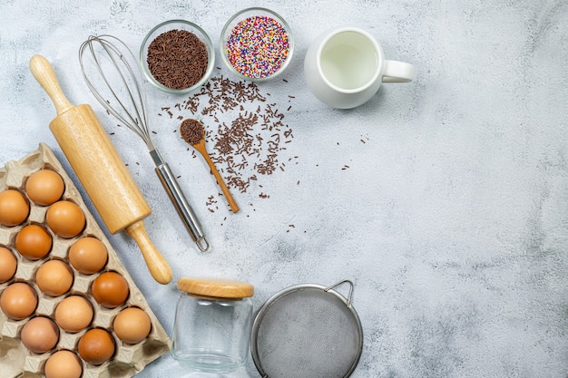 Foto cottura degli ingredienti culinari sbatti la farina di uova e il tessuto da cucina su grigio brillante