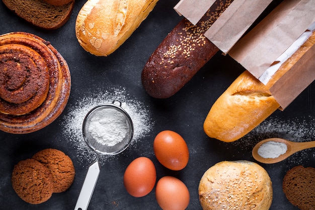 Baking ingredients for flour and rye bakery products. Fresh crisp bread, baguette packaged in paper bag and buns