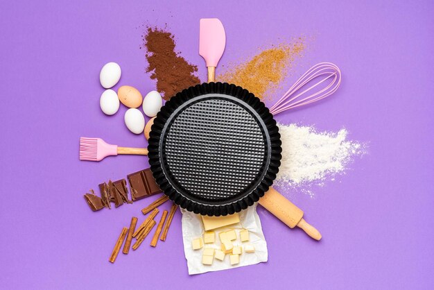 Baking ingredients and kitchen utensils flat lay sweet pie ingredients on a purple background