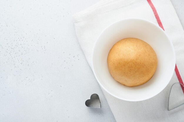 Baking ingredients and kitchen utensils on a white background top view Preparing heart sugar cookies Baking background Flour eggs sugar spices and a whisk on the kitchen table Flat lay