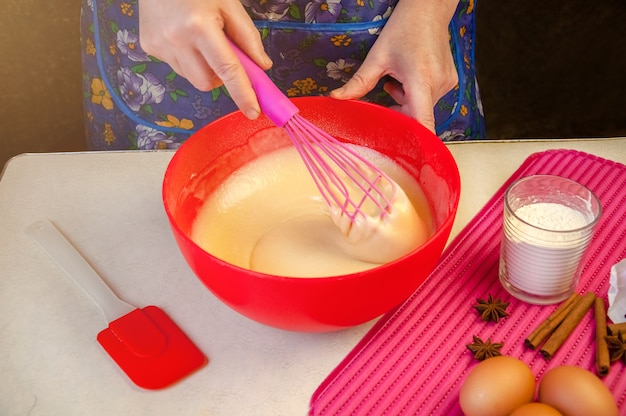 Выпечка Ингредиенты и посуда для приготовления бисквита. Процесс приготовления бисквита. Женщина, смешивая тесто