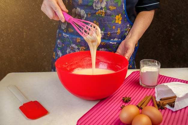 스폰지 케익 요리 용 베이킹 재료 및기구. 스펀지 케이크 요리. 반죽을 혼합하는 여자