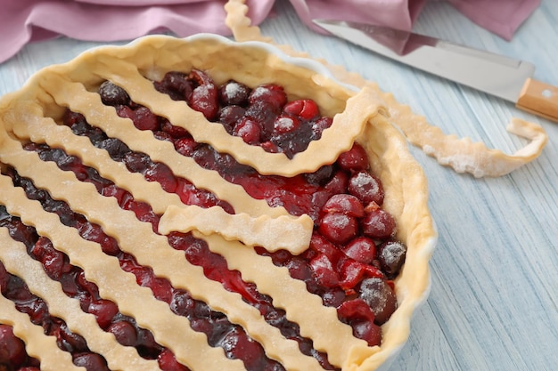 Baking pan with unbaked cherry pie on kitchen table