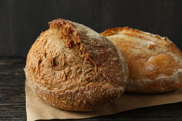 Baking paper with fresh bread on wooden table