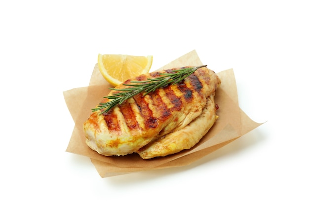 Baking paper with grilled chicken breast isolated on white background