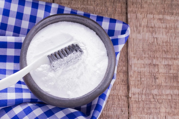 Baking soda and brush are the wooden table