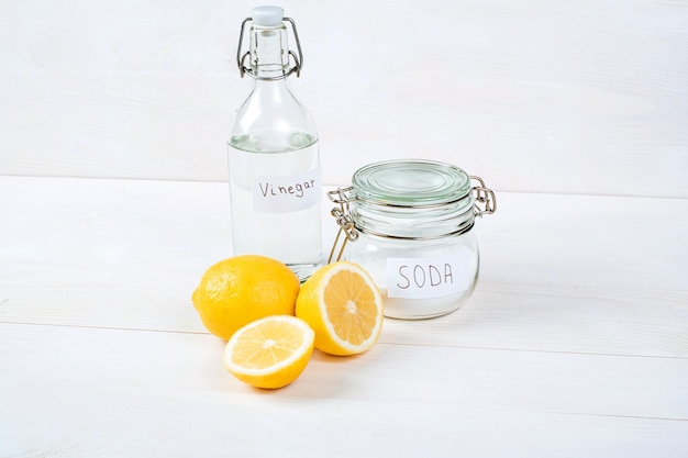 Baking soda in jar vinegar lemon on a white background The concept of removing stains on clothes