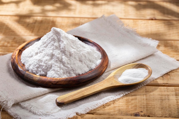 Baking soda in wooden bowl on the table