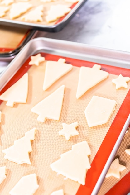 Baking sugar Christmas cookies in shape of Christmas trees.