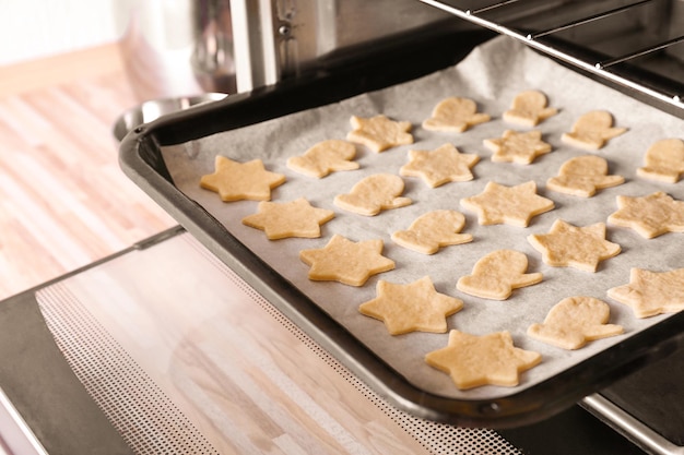 Baking tray with Christmas raw cookies in oven