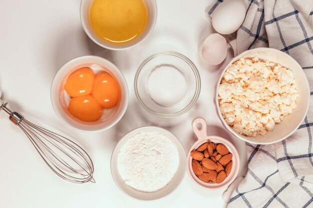 Baking utensils and cooking ingredients for a tarts, cookies, dough and pastry. Flat lay with eggs, flour, sugar, cottage cheese