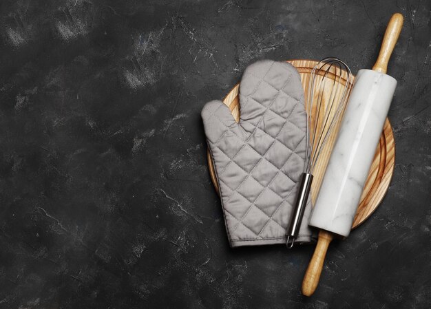 Baking utensils, whisk, rolling pin on a dark background