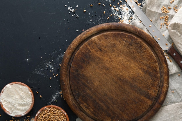 Bakken achtergrond, meel aan boord bij zwart. Bakkerij en thuis brood maken concept. Ruimte kopiëren