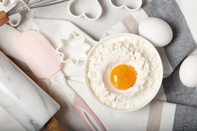 Bakken gebruiksvoorwerpen en ingrediënten. Deegroller, koekjesvorm op een grijze achtergrond. Pasen-concept.