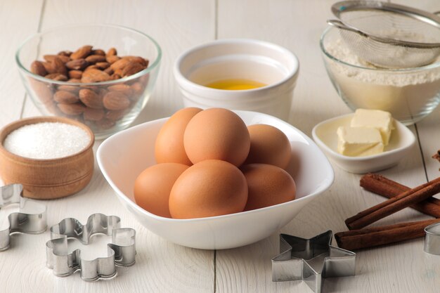 Bakken ingrediënten boter, eieren, suiker, op een witte houten achtergrond.