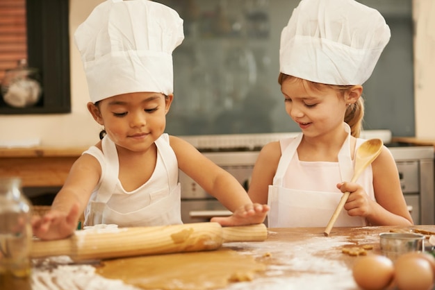 Bakken is zo leuk Twee kleine meisjes bakken samen in de keuken