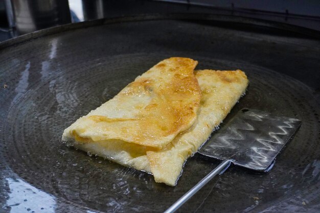 Bakken Martabak Telor of omelet martabak in hete olie Hartig panfried gebak gevuld met ei vlees en kruiden Traditionele snacks uit Indonesië