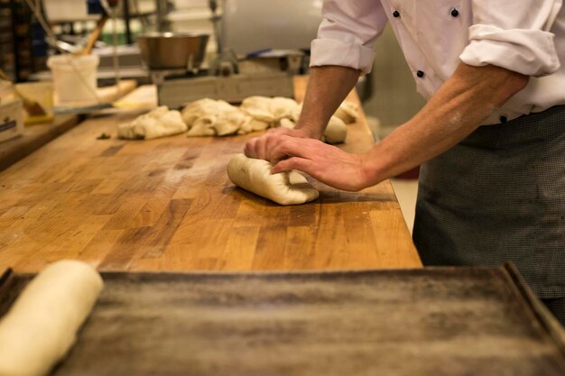 Bakker die deeg kneedt in een bakkerij