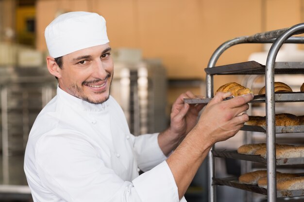 Bakker die vers gebakken brood controleert