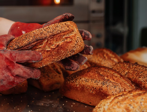 Bakker haalt vers gebakken brood uit de vorm
