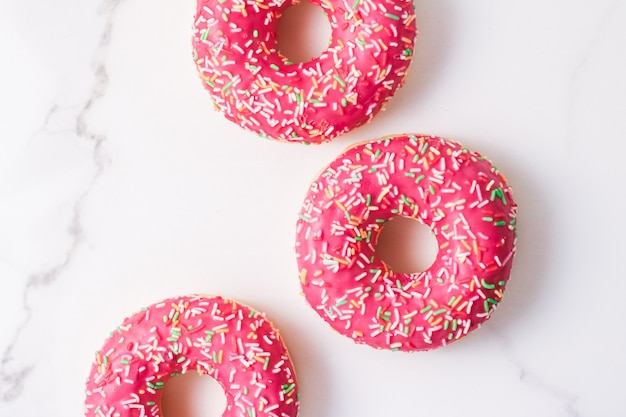 Bakkerij branding en café concept frosted besprenkeld donuts zoet gebak dessert op marmeren tafel achtergrond donuts als smakelijke snack bovenaanzicht voedsel merk plat lag voor blog menu of kookboek ontwerp