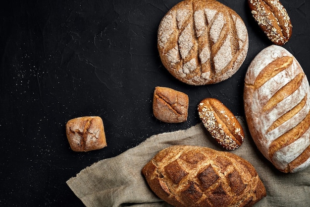 Bakkerij gouden rustieke knapperige broden en broodjes op zwarte bordachtergrond