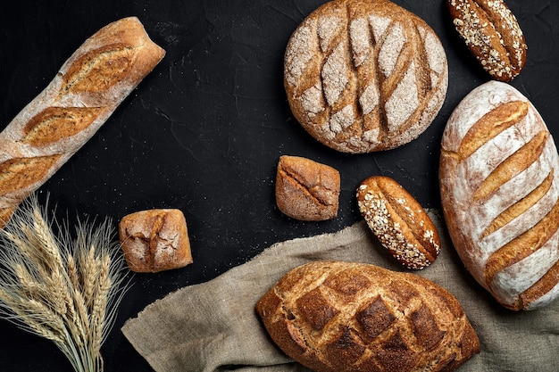 Bakkerij gouden rustieke knapperige broden en broodjes op zwarte bordachtergrond