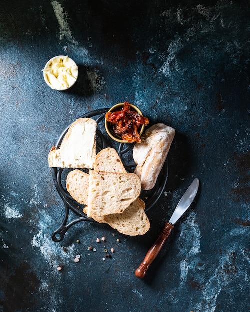 Bakkerij, knapperige broden. Stilleven gevangen van boven bovenaanzicht, plat lag. zongedroogde tomaten. Vegetarisch eten. Gezond eten concept. Boter. Belegd broodje. zuurdesembrood.