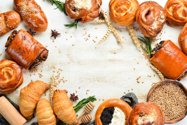 Bakkerij Set broodjes met jam kwark maanzaad en sesam op een witte houten achtergrond Bakken van rogge en bloem Bovenaanzicht rustieke stijl