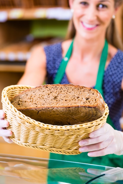 Bakkerijverkoopster die brood aanbiedt