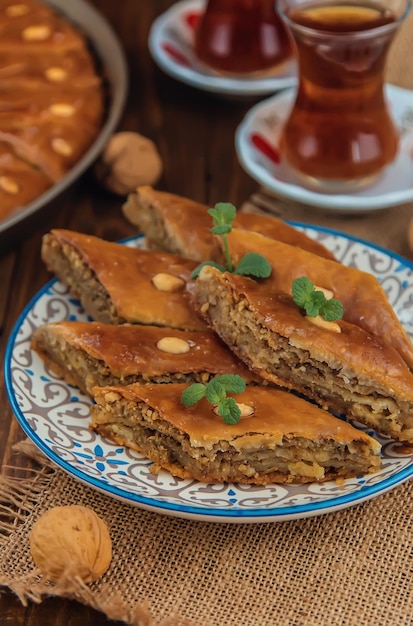 Baklava on the table and tea in Turkish glasses. Selective focus.