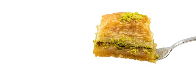 Foto baklava con pistacchio isolato su sfondo bianco baklava sulla forchetta delizie della cucina tradizionale turca copia spazio