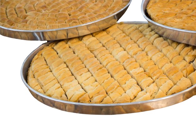 Baklava zoet gebakje met noten in dienblad dat op witte achtergrond wordt geïsoleerd