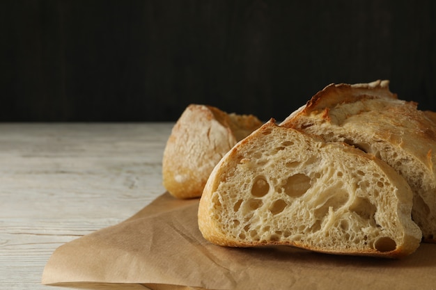 Bakpapier met brood op witte houten achtergrond