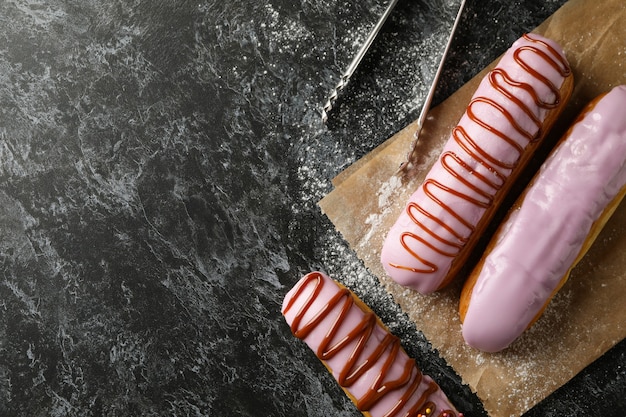 Bakpapier met smakelijke eclairs op zwarte smokey