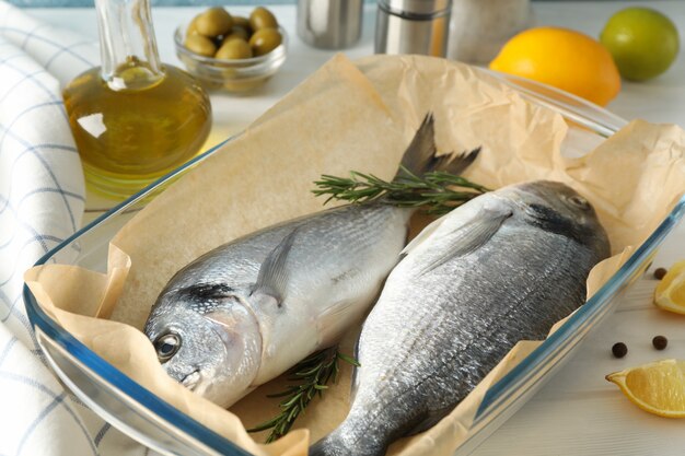 Bakplaat met Dorado-vissen en kookingrediënten op hout