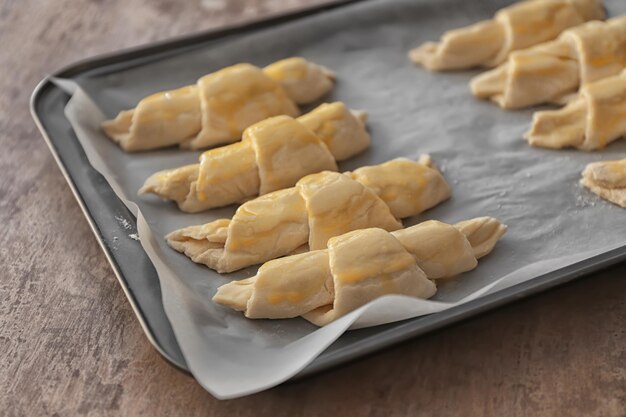 Bakplaat met rauwe croissants op tafel close-up