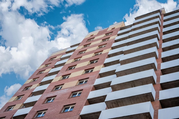 Baksteen nieuwe gebouwen met meerdere appartementen tegen de achtergrond van een mooie bewolkte hemel.